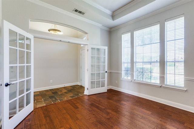 empty room featuring french doors, crown molding, wood finished floors, and baseboards