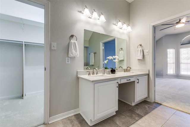full bath with baseboards, ceiling fan, double vanity, and tile patterned flooring