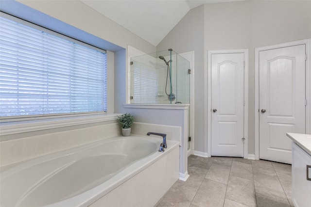 bathroom featuring a stall shower, a bath, lofted ceiling, vanity, and tile patterned floors
