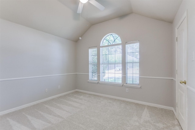 carpeted empty room featuring a ceiling fan, lofted ceiling, and baseboards