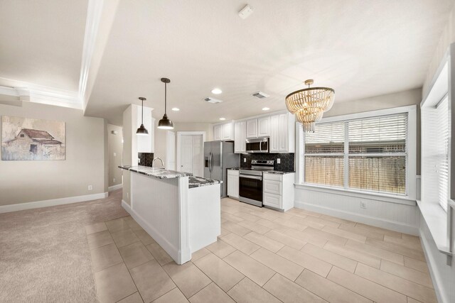 816 Ridgecrest Ct, Aubrey, TX 76227 - kitchen with stainless steel appliances, a chandelier, wainscoting, white cabinetry, and backsplash