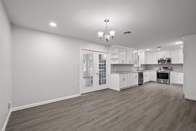 2001 Brenda Ave, Denison, TX 75020 - kitchen featuring stainless steel appliances, a sink, open shelves, backsplash, and baseboards