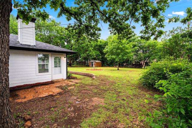 2001 Brenda Ave, Denison, TX 75020 - view of green lawn featuring a storage unit, an outdoor structure, and view of scattered trees