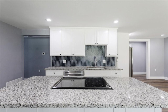 3015 S Fannin Ave, Denison, TX 75021 - kitchen with a sink, stovetop, dishwasher, white cabinetry, and backsplash