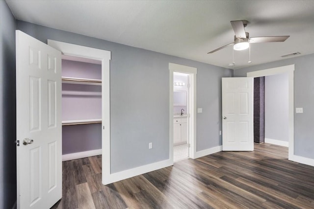 3015 S Fannin Ave, Denison, TX 75021 - unfurnished bedroom with dark wood-type flooring, a spacious closet, baseboards, a closet, and ensuite bath