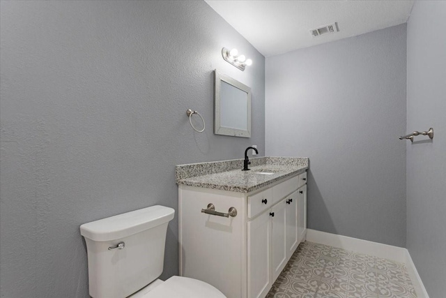 3015 S Fannin Ave, Denison, TX 75021 - bathroom featuring baseboards, toilet, and vanity