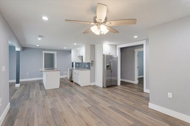 3015 S Fannin Ave, Denison, TX 75021 - kitchen featuring appliances with stainless steel finishes, white cabinets, ceiling fan, baseboards, and wood finished floors