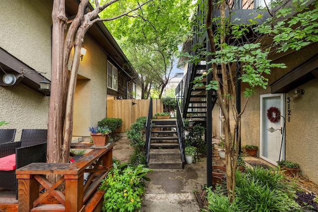 3103 Wycliff Ave, Dallas, TX 75219 - view of side of home with stucco siding, stairs, and fence