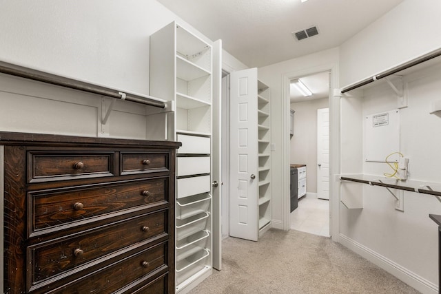 walk in closet featuring light colored carpet