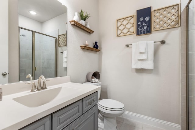 bathroom with tiled shower, tile patterned flooring, toilet, and vanity
