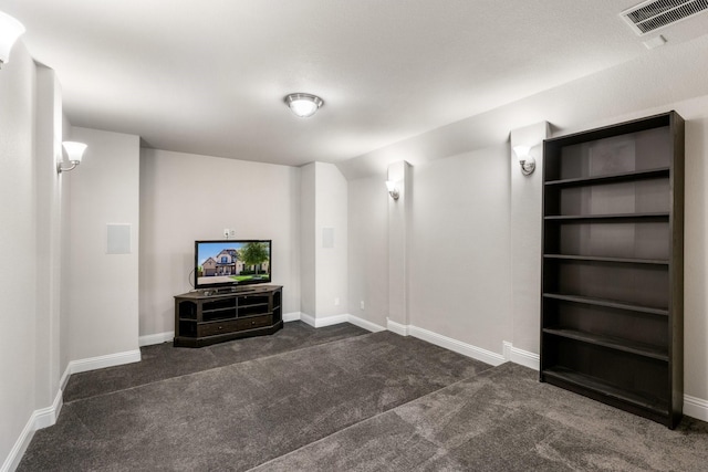 unfurnished living room with dark carpet and baseboards
