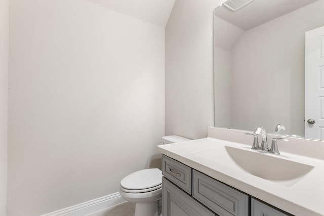 bathroom with vanity, toilet, and baseboards