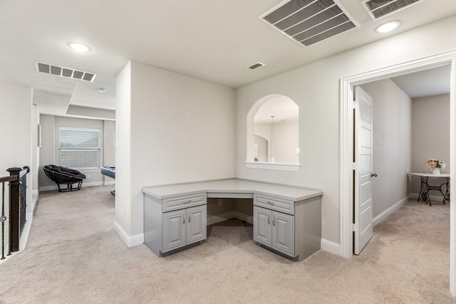 unfurnished office with light colored carpet, baseboards, and built in study area