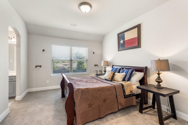 bedroom with carpet floors, arched walkways, and baseboards