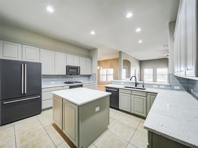 kitchen featuring high end refrigerator, dishwashing machine, a sink, tasteful backsplash, and a peninsula