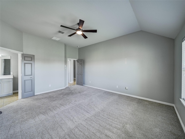 unfurnished bedroom featuring light colored carpet, baseboards, lofted ceiling, and ceiling fan