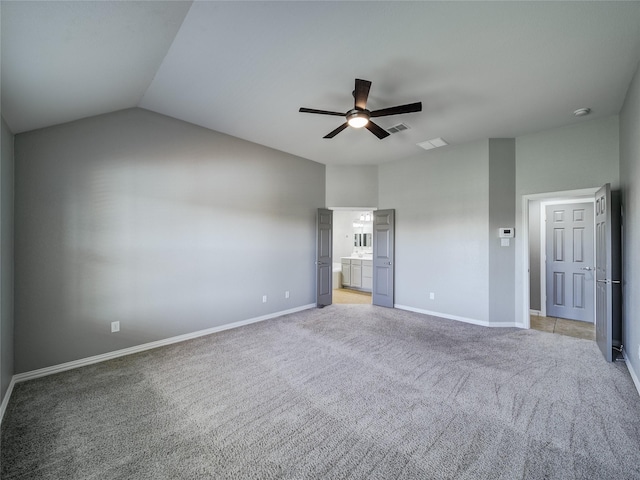 unfurnished bedroom with light colored carpet, baseboards, ensuite bath, lofted ceiling, and a ceiling fan