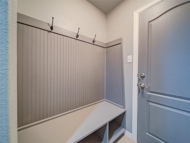mudroom featuring a textured wall and a textured ceiling