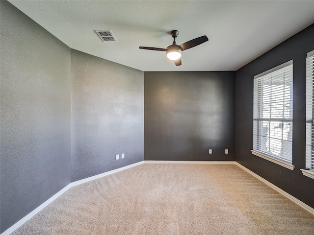 empty room featuring ceiling fan, carpet flooring, baseboards, and a textured wall