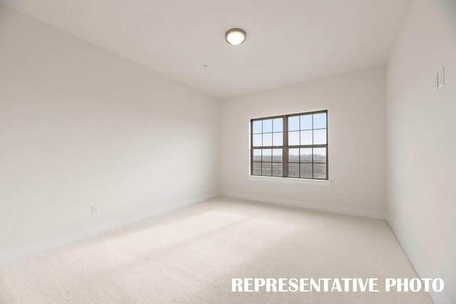 unfurnished room featuring light carpet and baseboards
