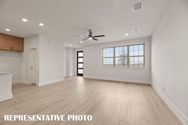 unfurnished living room featuring recessed lighting, light wood-style flooring, a ceiling fan, and baseboards