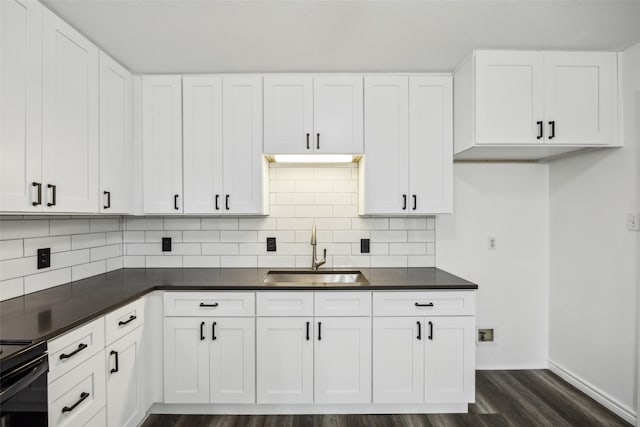 182 Willowcreek Ln, Rockwall, TX 75032 - kitchen featuring a sink, dark countertops, dark wood-style flooring, and backsplash