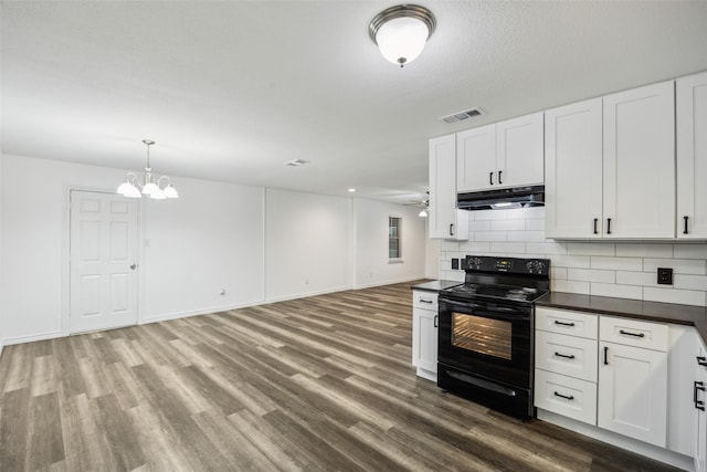 182 Willowcreek Ln, Rockwall, TX 75032 - kitchen featuring black electric range, under cabinet range hood, dark countertops, dark wood-style floors, and backsplash