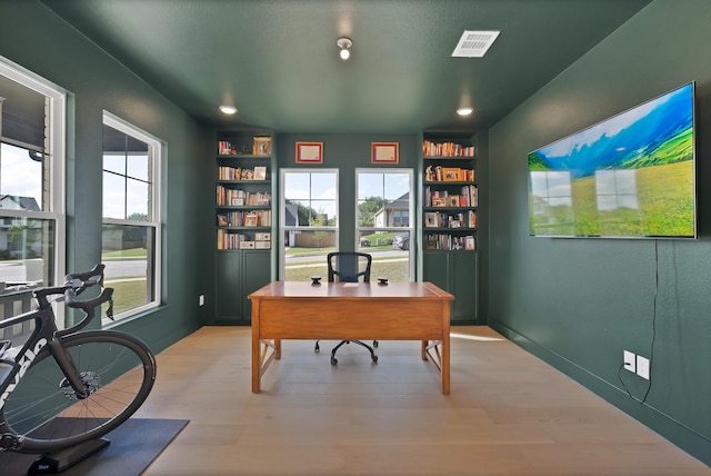 office with built in shelves, wood finished floors, and recessed lighting