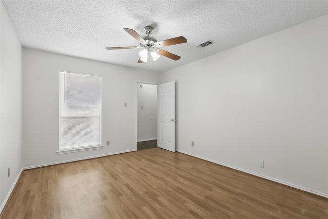1021 Irene St, Burleson, TX 76028 - unfurnished bedroom with wood finished floors, a textured ceiling, baseboards, and ceiling fan