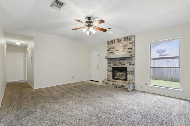 1021 Irene St, Burleson, TX 76028 - unfurnished living room with vaulted ceiling, carpet floors, a fireplace, ceiling fan, and a textured ceiling