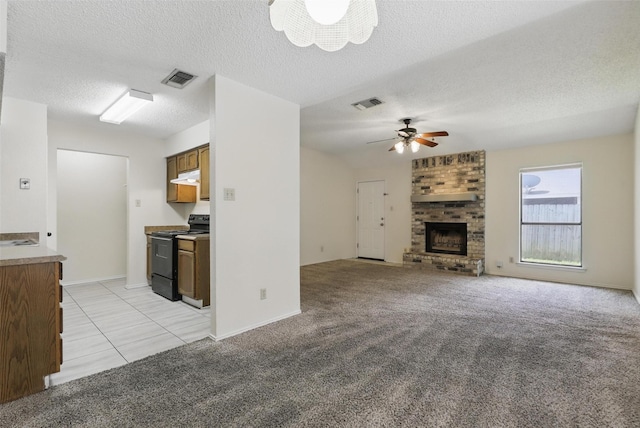 1021 Irene St, Burleson, TX 76028 - unfurnished living room featuring a fireplace, a textured ceiling, ceiling fan, light colored carpet, and light tile patterned floors