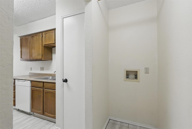 1021 Irene St, Burleson, TX 76028 - washroom with washer hookup, a textured ceiling, a sink, and baseboards
