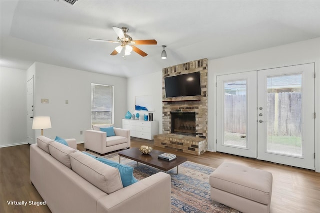 1021 Irene St, Burleson, TX 76028 - living room with wood finished floors, a ceiling fan, a fireplace, and french doors