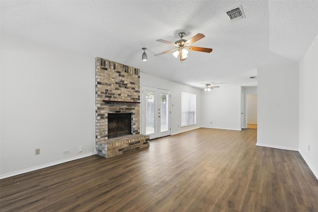 1021 Irene St, Burleson, TX 76028 - unfurnished living room featuring a ceiling fan, wood finished floors, a brick fireplace, baseboards, and a textured ceiling