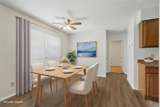 1021 Irene St, Burleson, TX 76028 - dining room featuring dark wood-style floors, a ceiling fan, baseboards, and a textured ceiling