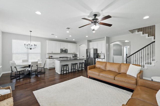 3200 Hawks View Ln, Denton, TX 76208 - living area with arched walkways, a ceiling fan, stairway, dark wood-style floors, and a chandelier