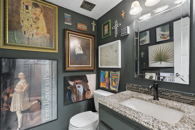 1738 Northaven Ct, Arlington, TX 76012 - bathroom featuring toilet, backsplash, a textured ceiling, and vanity