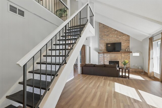 1738 Northaven Ct, Arlington, TX 76012 - staircase with wood finished floors, high vaulted ceiling, a fireplace, and beamed ceiling