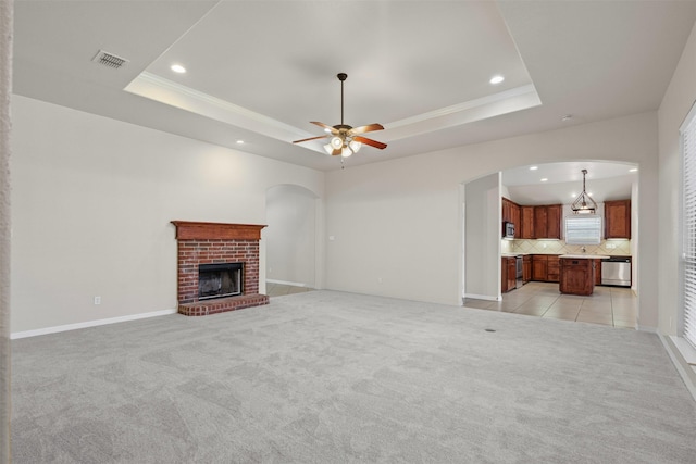 6328 Pinionpark Way, Fort Worth, TX 76179 - unfurnished living room featuring recessed lighting, a tray ceiling, arched walkways, and light colored carpet