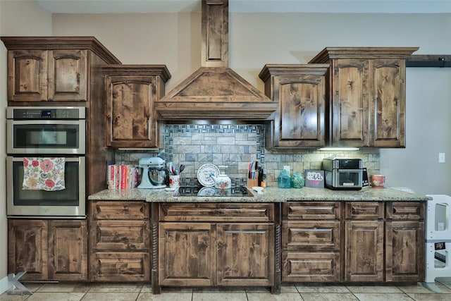 3726 Enchanted Rock Rd, Abilene, TX 79606 - kitchen featuring custom range hood, backsplash, dark brown cabinetry, light stone countertops, and black electric cooktop