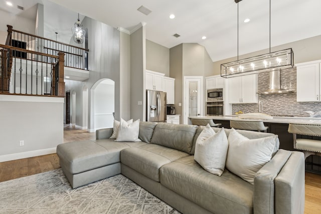 2831 Sheffield Ct, Trophy Club, TX 76262 - living area featuring a high ceiling, light wood-type flooring, arched walkways, stairway, and a chandelier