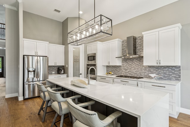 2831 Sheffield Ct, Trophy Club, TX 76262 - kitchen featuring stainless steel appliances, wall chimney range hood, a sink, backsplash, and a breakfast bar