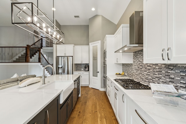 2831 Sheffield Ct, Trophy Club, TX 76262 - kitchen with wall chimney range hood, appliances with stainless steel finishes, a sink, white cabinets, and recessed lighting