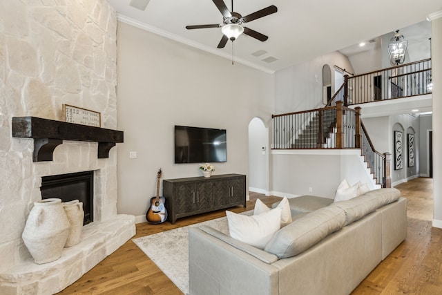 2831 Sheffield Ct, Trophy Club, TX 76262 - living area with arched walkways, ceiling fan, stairway, a fireplace, and ornamental molding