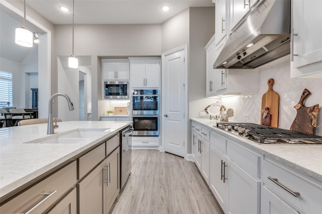 771 Drummond Dr, Prosper, TX 75078 - kitchen with under cabinet range hood, appliances with stainless steel finishes, a sink, pendant lighting, and decorative backsplash