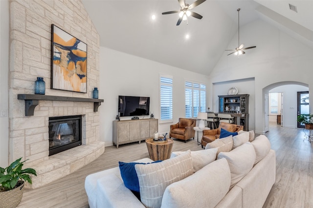 771 Drummond Dr, Prosper, TX 75078 - living area with a ceiling fan, high vaulted ceiling, arched walkways, a stone fireplace, and plenty of natural light