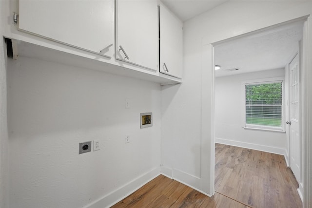 laundry area with electric dryer hookup, cabinet space, wood finished floors, hookup for a washing machine, and baseboards