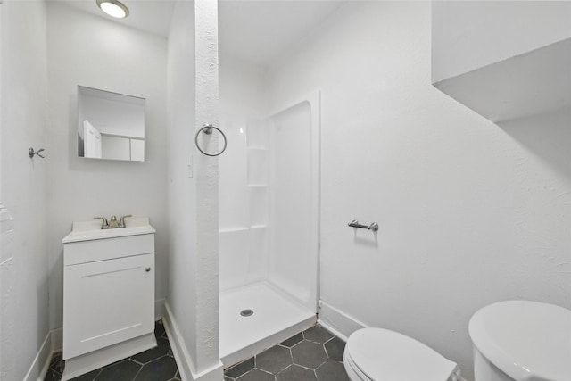 bathroom featuring toilet, tile patterned floors, a stall shower, and vanity