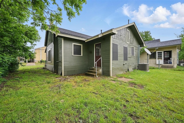 rear view of house featuring central AC, board and batten siding, and entry steps