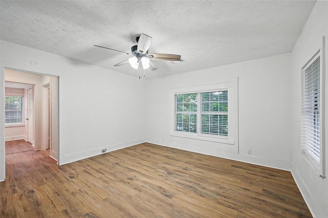 unfurnished bedroom featuring wood finished floors, a textured ceiling, baseboards, and ceiling fan